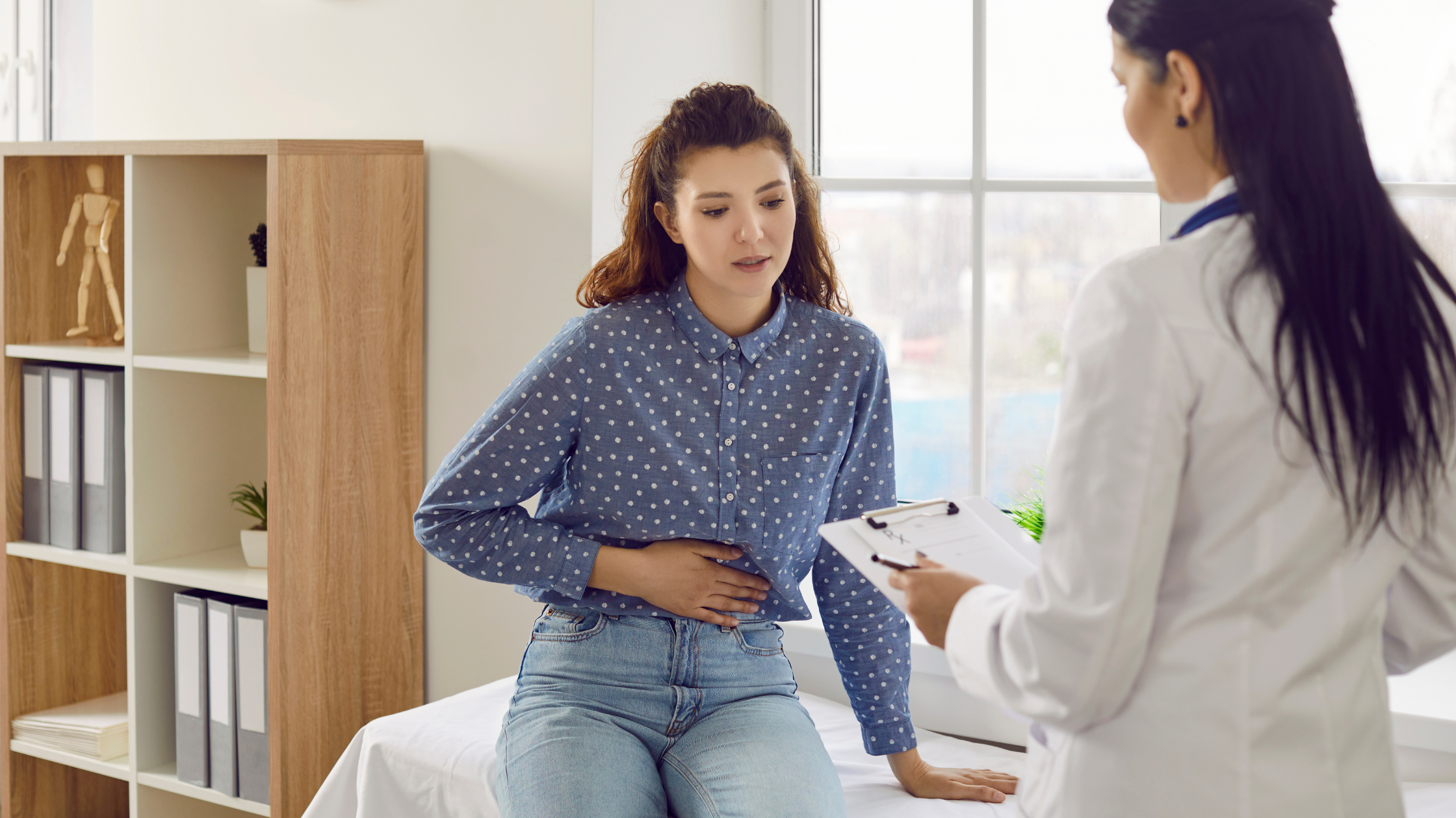 girl patient with doctor experiencing stomach pain from a hernia